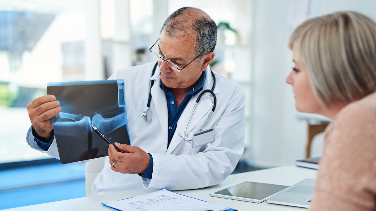 doctor reviewing x-ray with his patient Doctor reviewing x-ray with his female patient