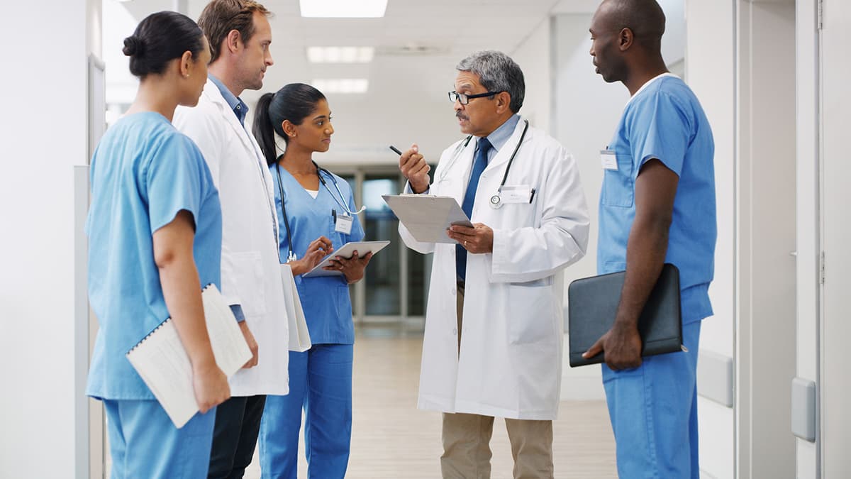 doctor with staff a doctor talking to clinic staff members